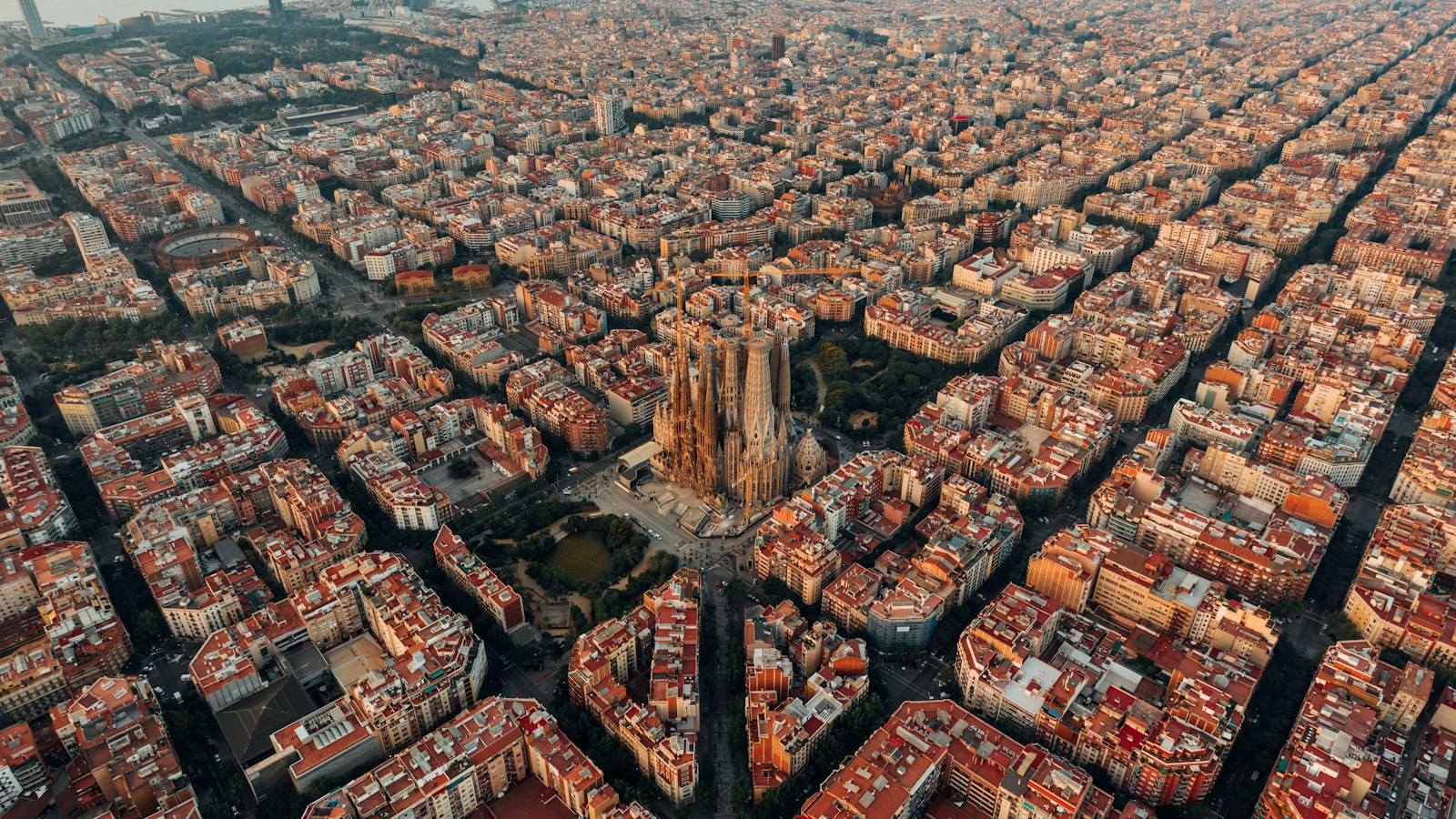 Aerial view of Barcelona's Eixample grid and the Sagrada Família at golden hour